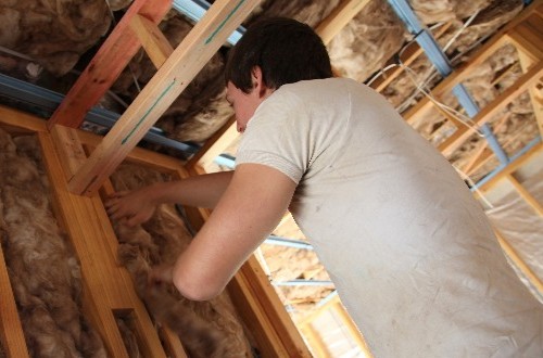 man insulating a room
